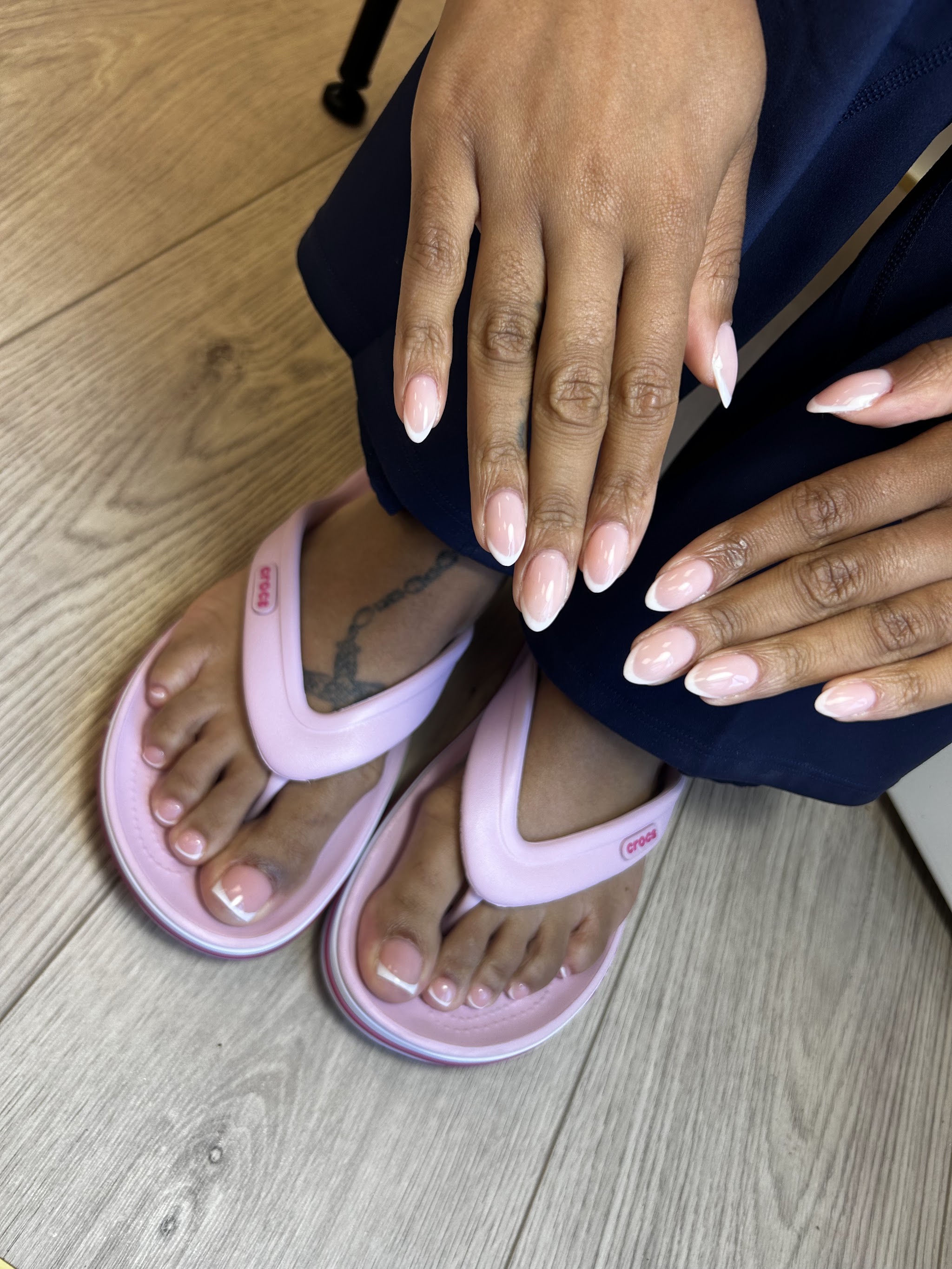 Roze nagels op handen en voeten in lila slippers