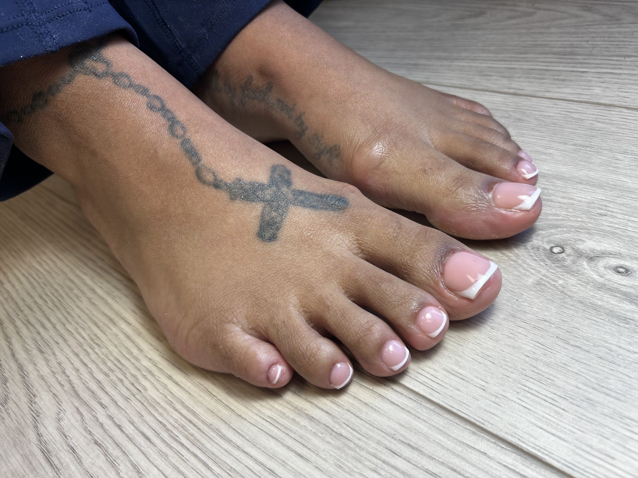 Pedicure met witte French tips op een houten vloer