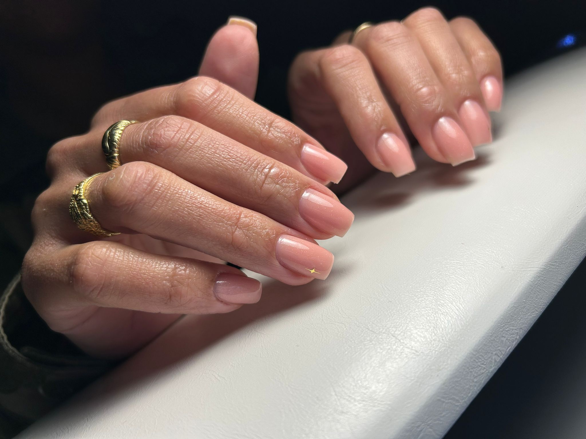 Nude nagels met gouden ringen